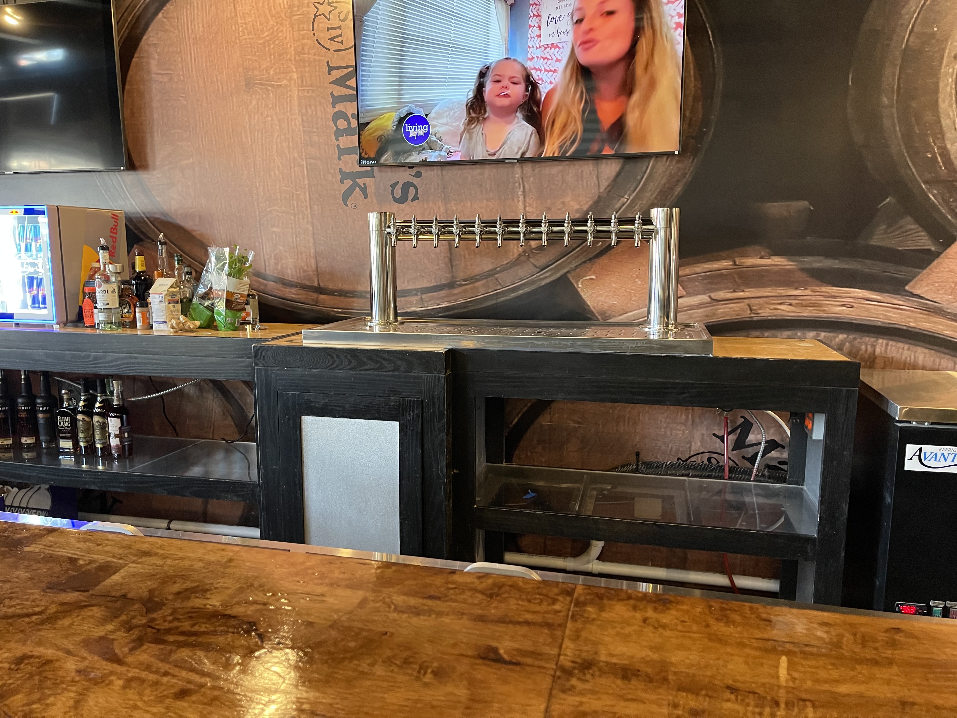 Close-up of dual-column stainless pedestal draft tower on dark wood bar